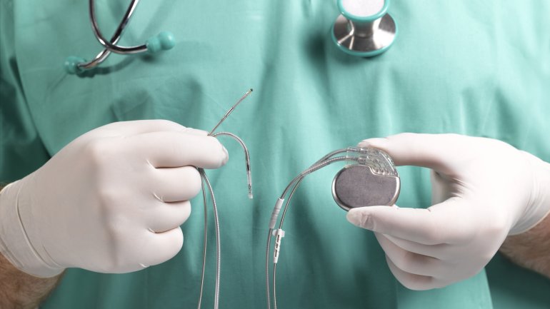 Arzt hält Herzschrittmacher in den Händen