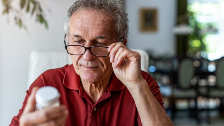Älterer Mann liest Hinweise zu Blutverdünnerm