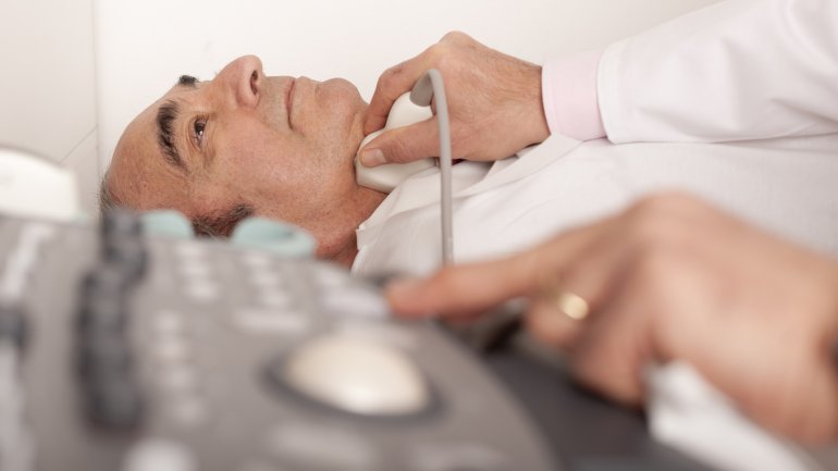 Ältere Mann wird per Ultraschall am Hals auf eine bestehende Carotisstenose hin untersucht.